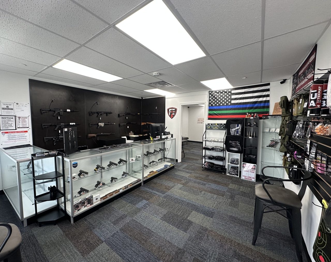Firearms Express retail counter with handguns in the display case and long guns on the wall — Sussex NJ gun shop